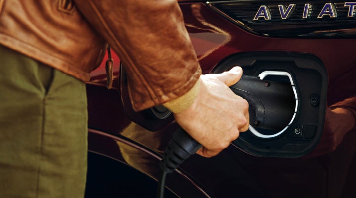 A hand is shown plugging in the charger into the charging port of a 2021 Lincoln Aviator | Holmes Tuttle Lincoln in Tucson AZ