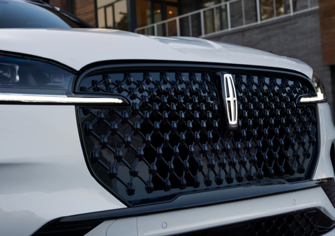 The black grille of a white 2025 Lincoln Aviator® SUV is shown with its fog lights on. | Holmes Tuttle Lincoln in Tucson AZ