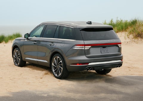 A 2027 Lincoln Aviator® SUV is parked next to sand dunes. | Holmes Tuttle Lincoln in Tucson AZ