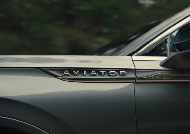 The driver’s side door and fender badging of a gray 2027 Lincoln Aviator® SUV are showcased. | Holmes Tuttle Lincoln in Tucson AZ
