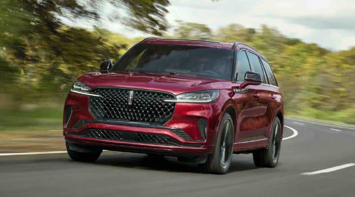 A 2027 Lincoln Aviator® SUV is being driven on a country road | Holmes Tuttle Lincoln in Tucson AZ