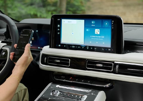 A person pairs thier phone with the center touchscreen of a 2027 Lincoln Aviator® Black Label™ SUV | Holmes Tuttle Lincoln in Tucson AZ